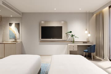 a room with two beds and a tv on the wall