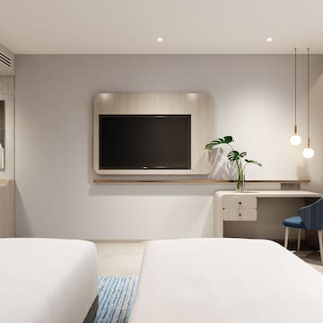 a room with two beds and a tv on the wall