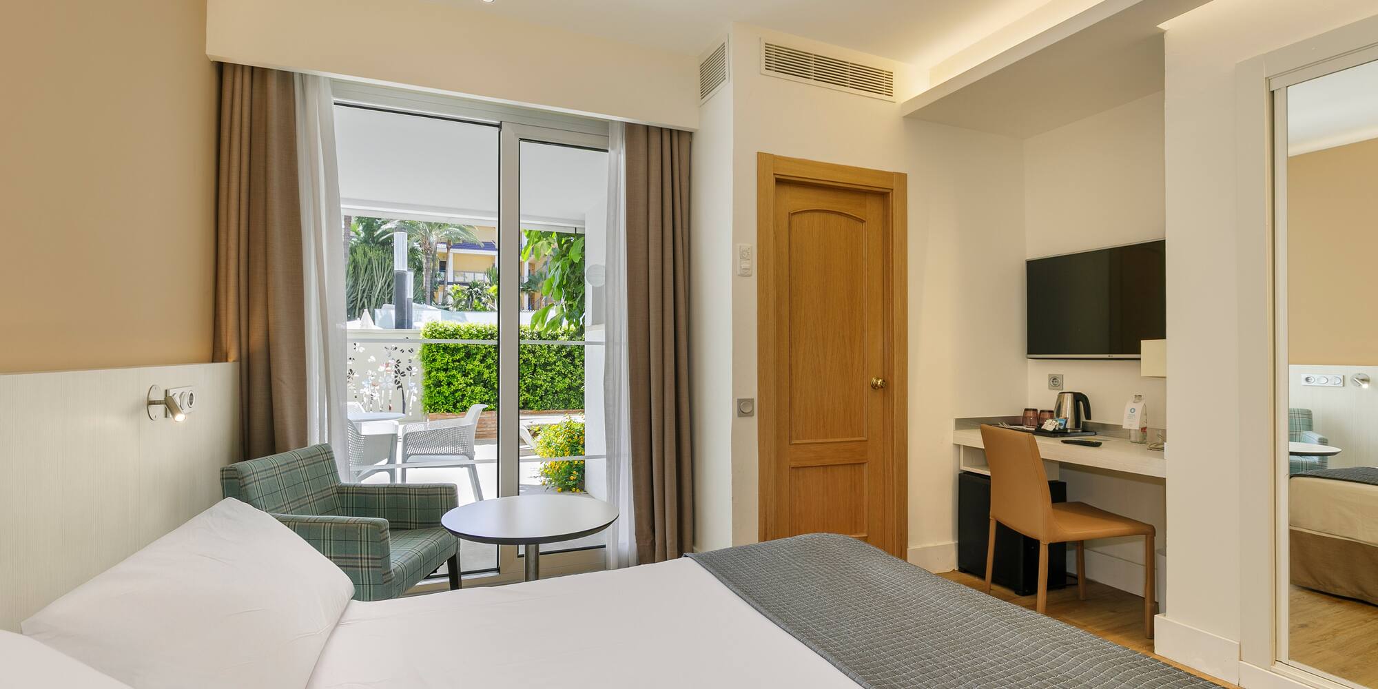 a room with a bed and a table and chairs