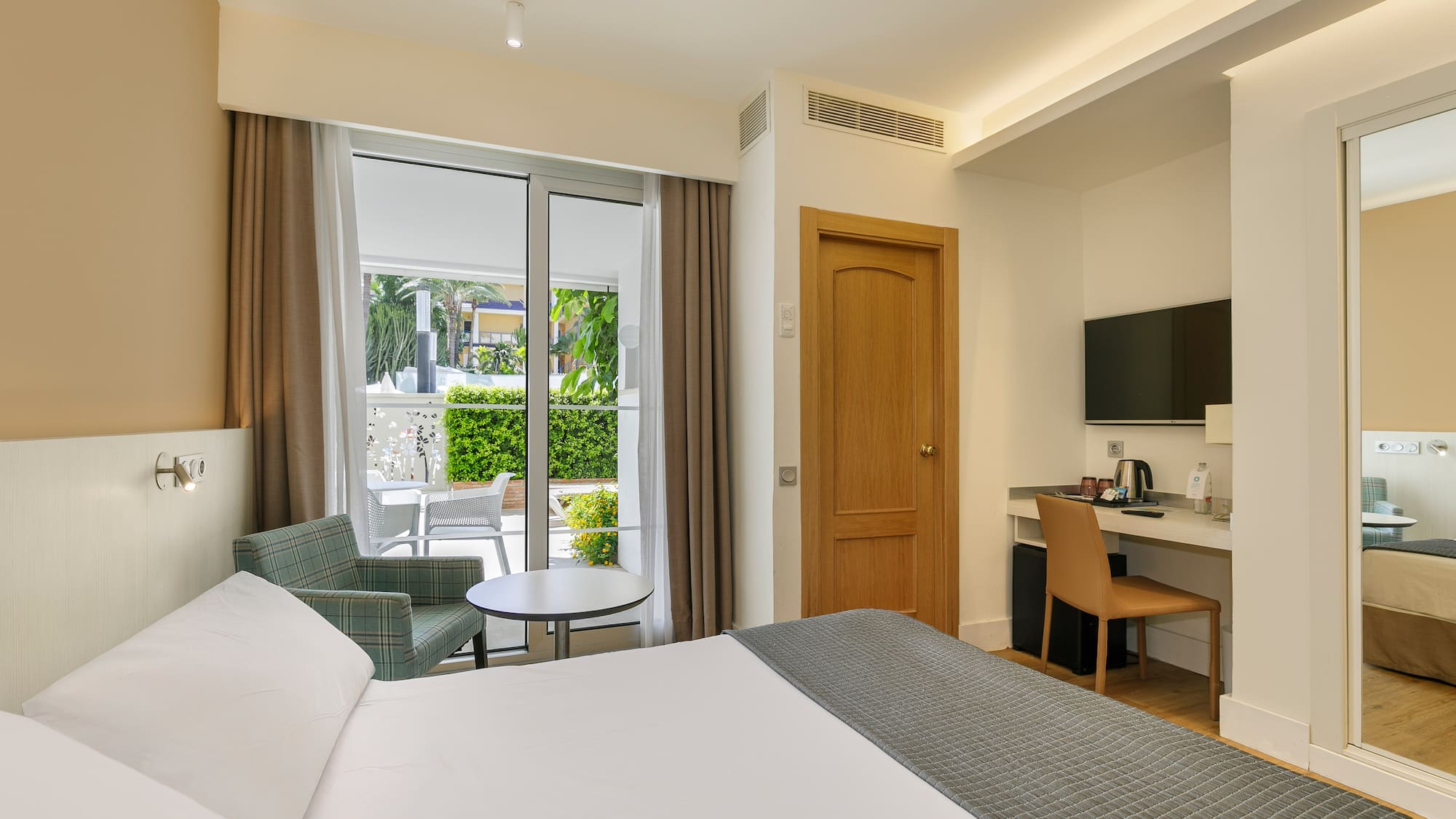 a room with a bed and a table and chairs