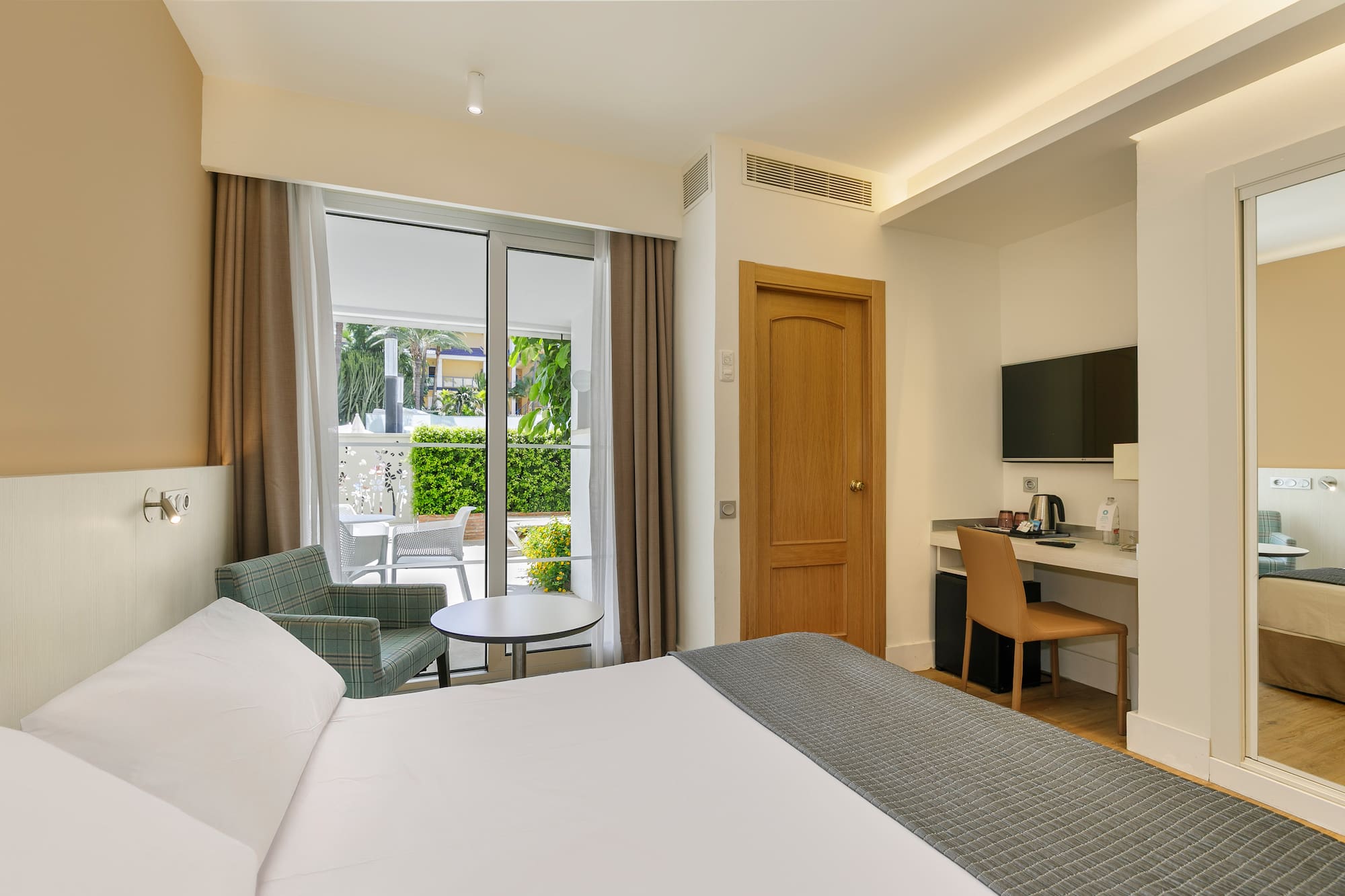 a room with a bed and a table and chairs