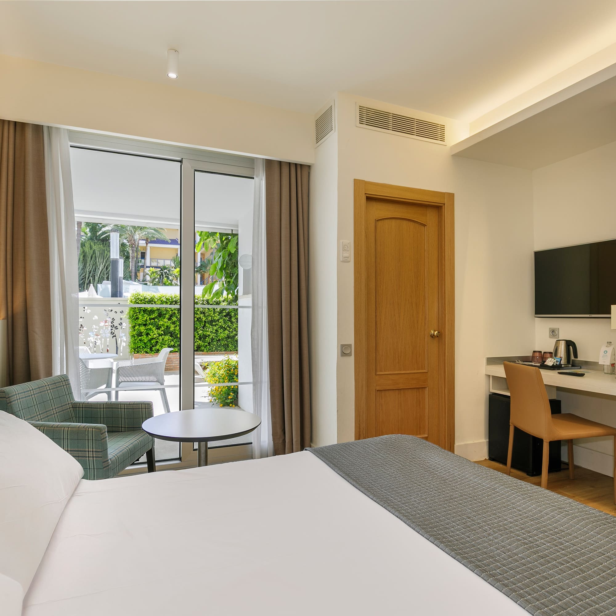 a room with a bed and a table and chairs