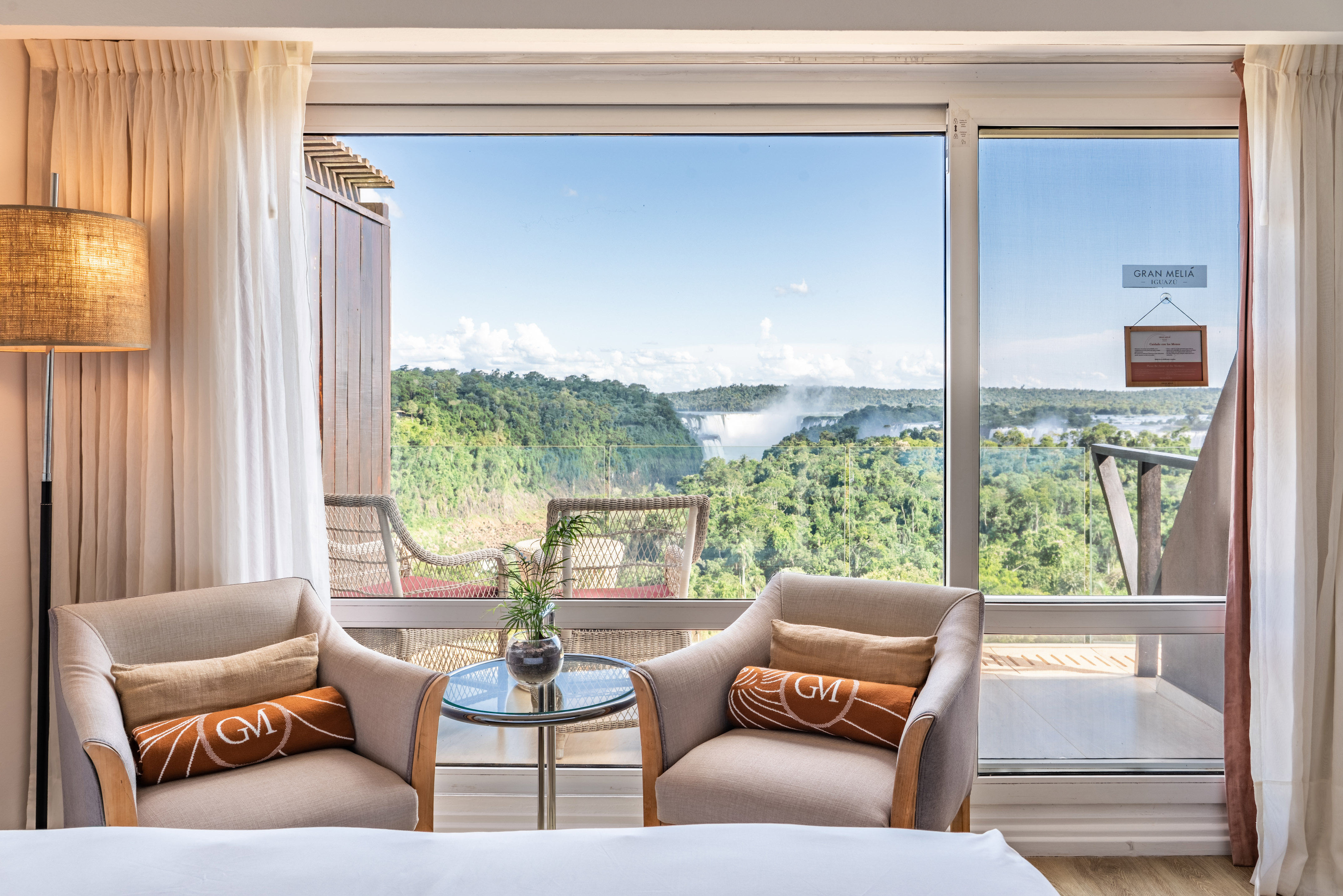 Iguazu Falls hotel room with armchairs and jungle waterfall view.