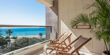 chairs on a balcony overlooking a beach