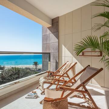 chairs on a balcony overlooking a beach