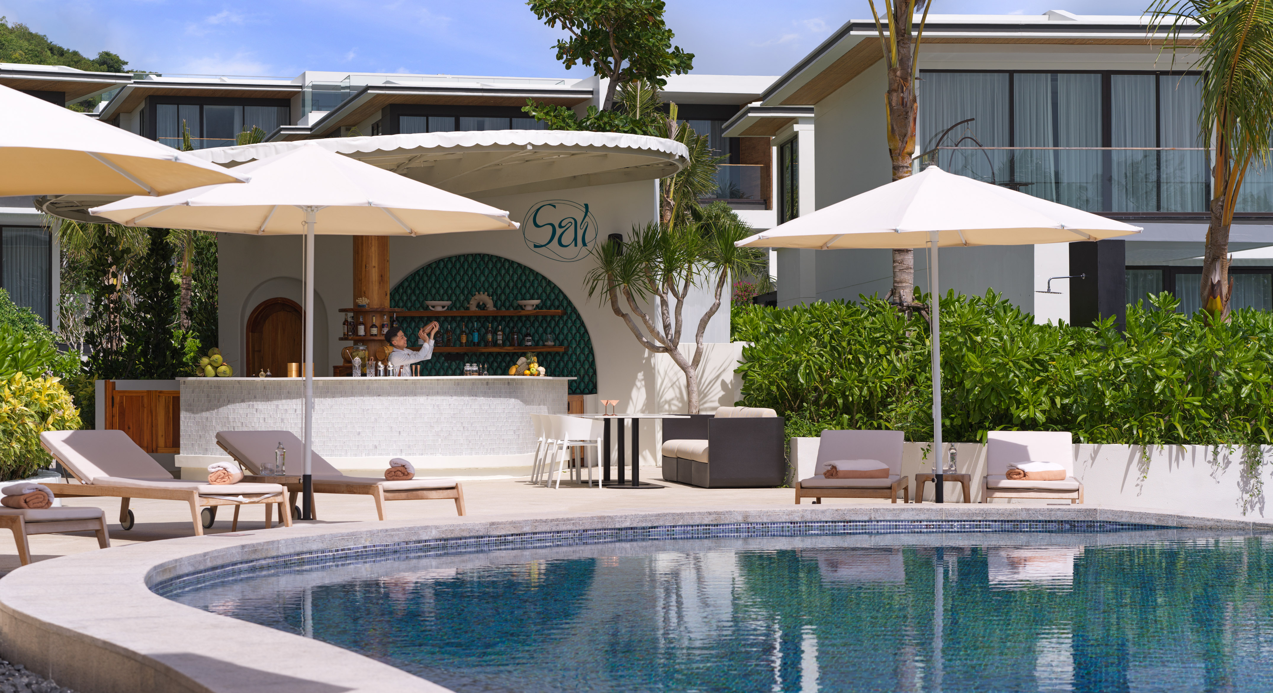Tropical resort pool deck with 'Sal' bar, bartender, and lounge chairs.