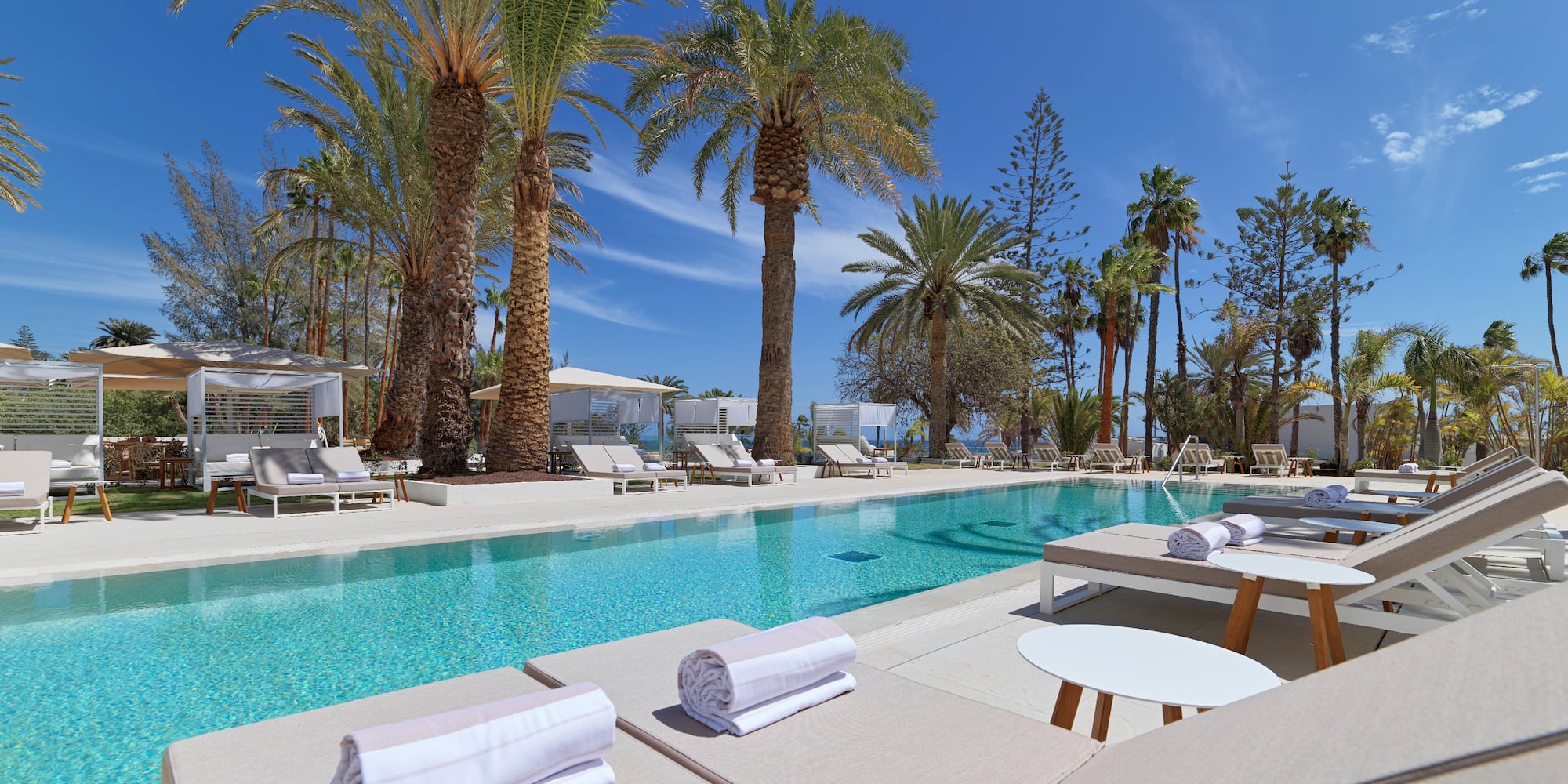 a pool with lounge chairs and tables and chairs