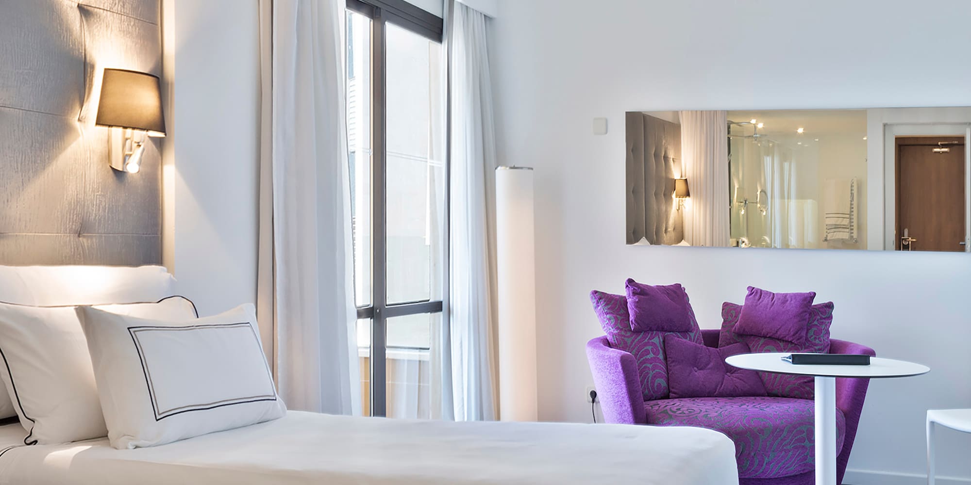 a room with two beds and a purple chair