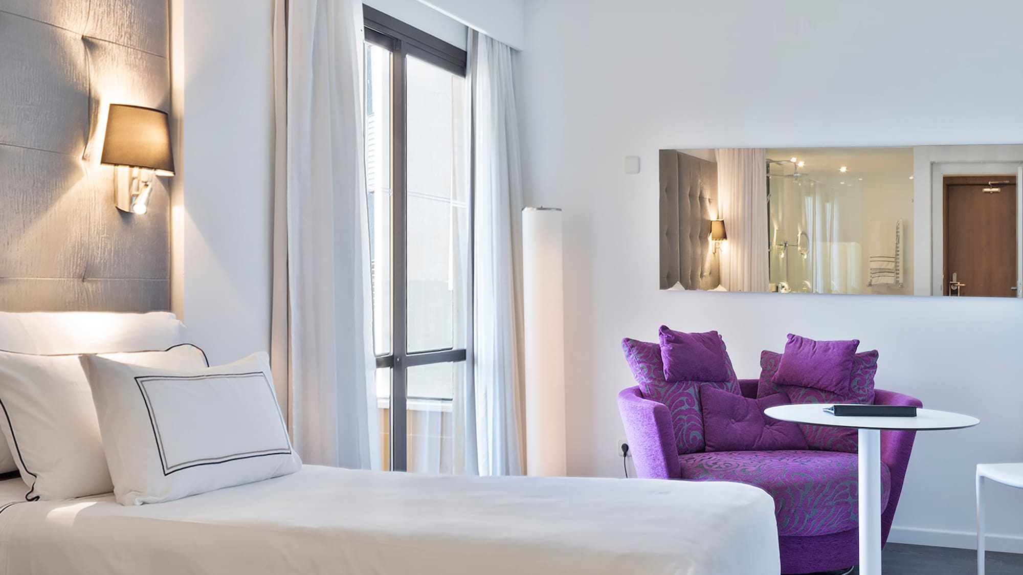 a room with two beds and a purple chair