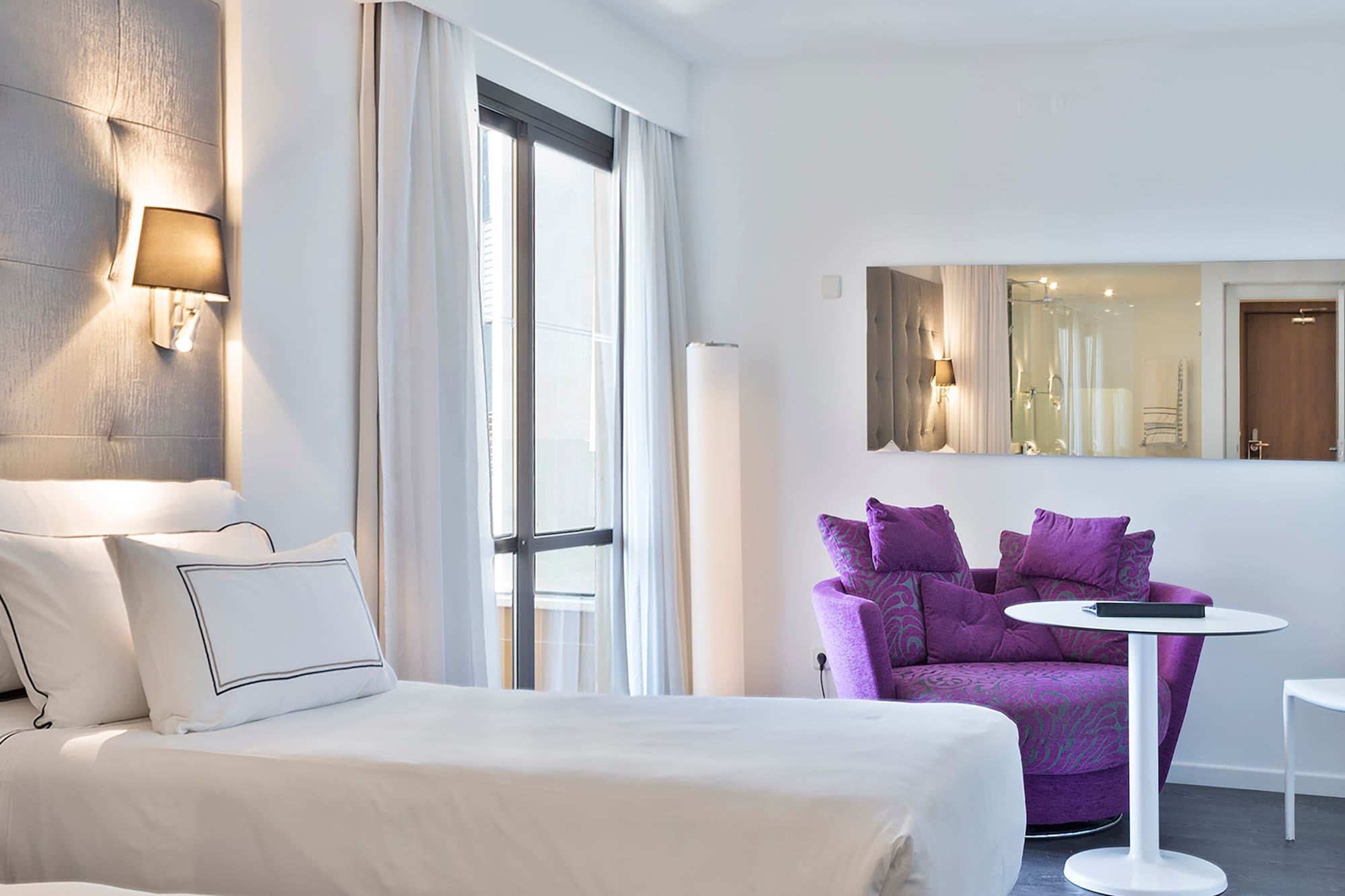 a room with two beds and a purple chair