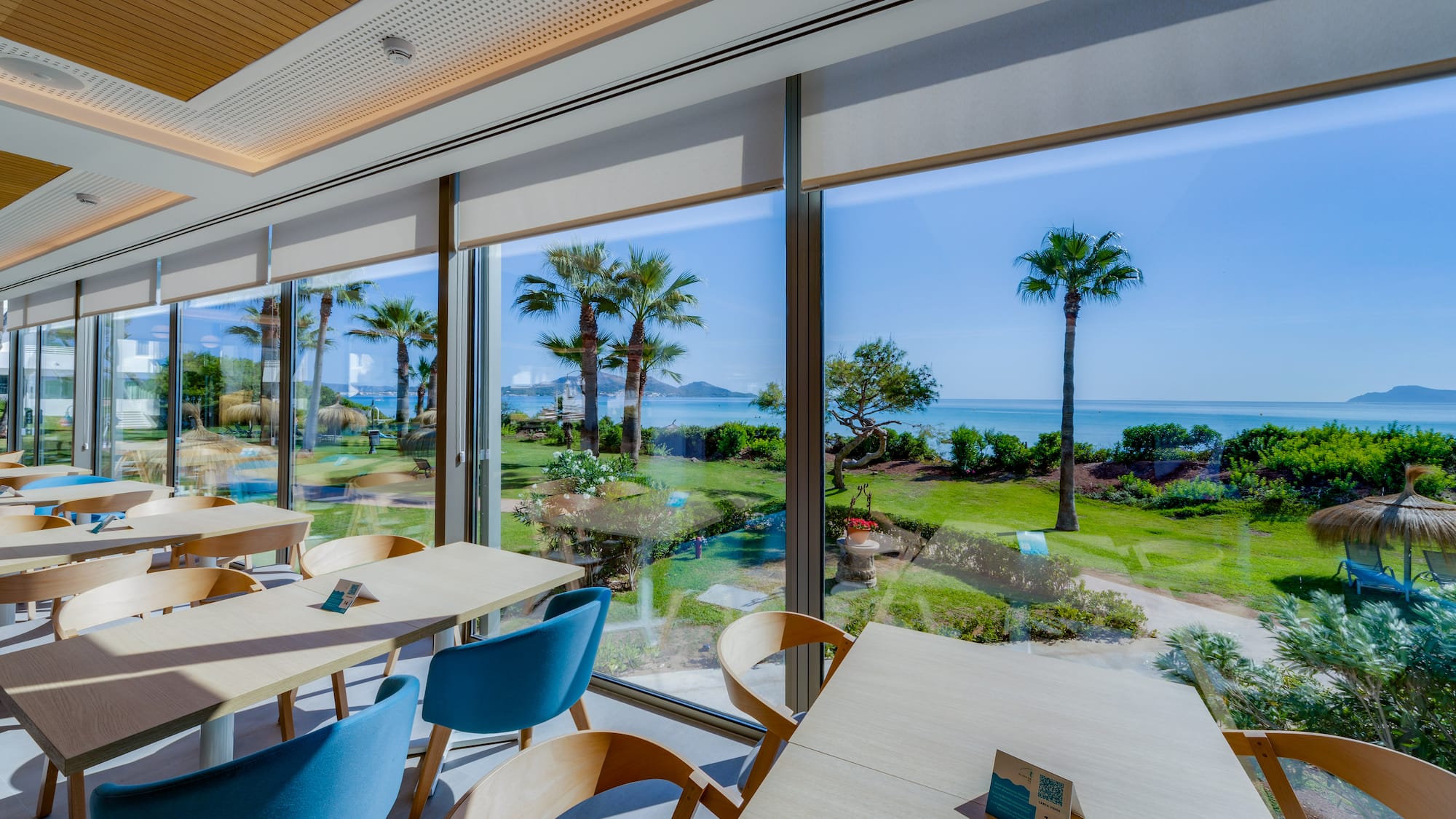 a room with a view of the ocean and palm trees
