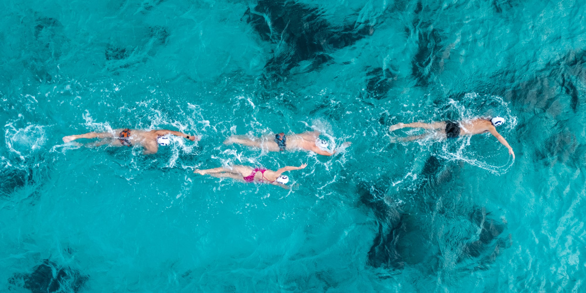 a group of people swimming in clear blue water