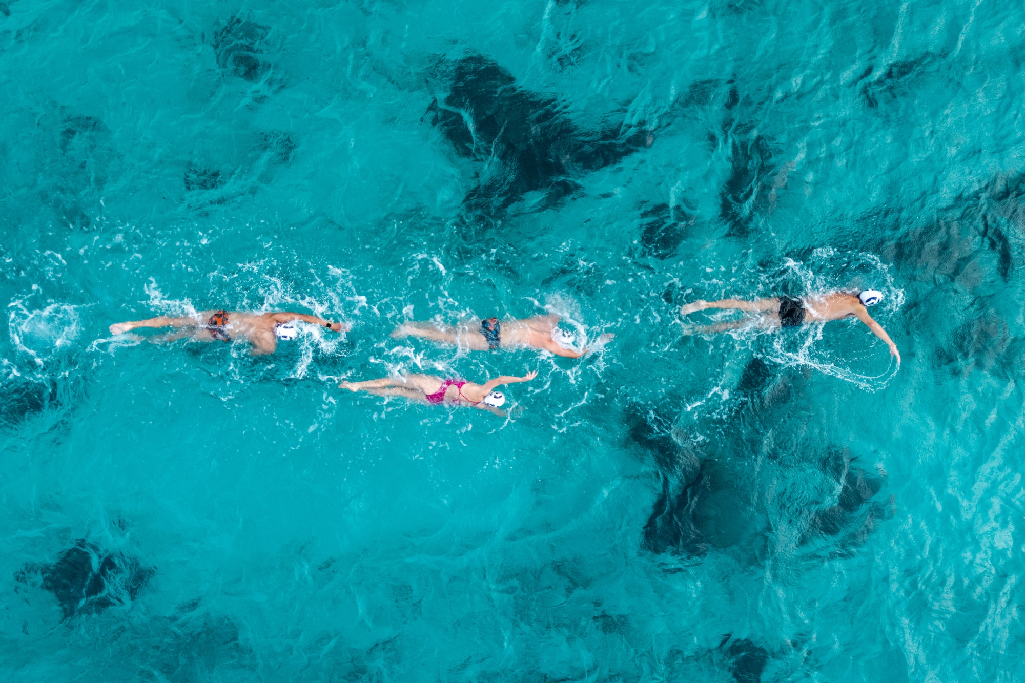 a group of people swimming in clear blue water