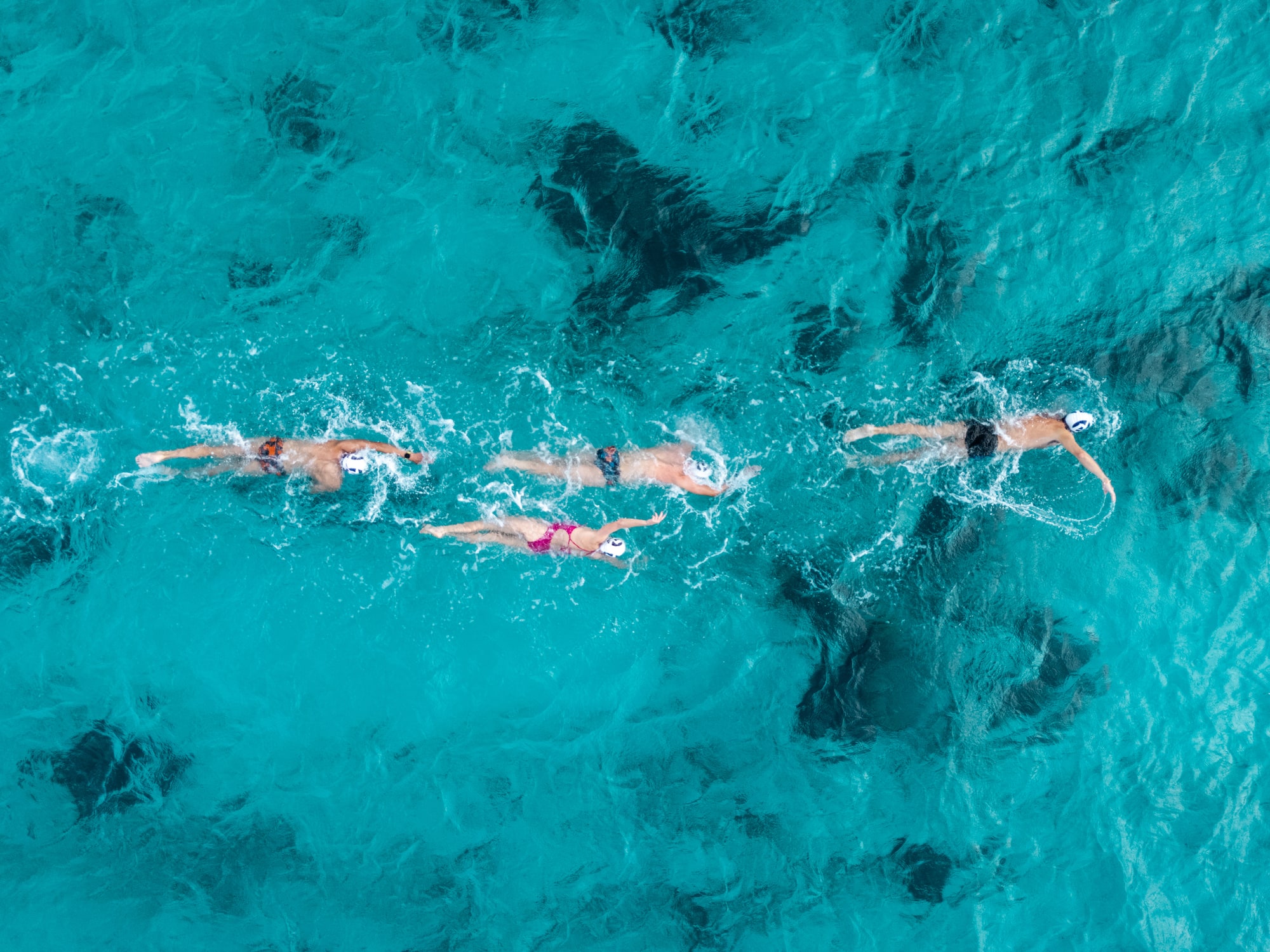 a group of people swimming in clear blue water