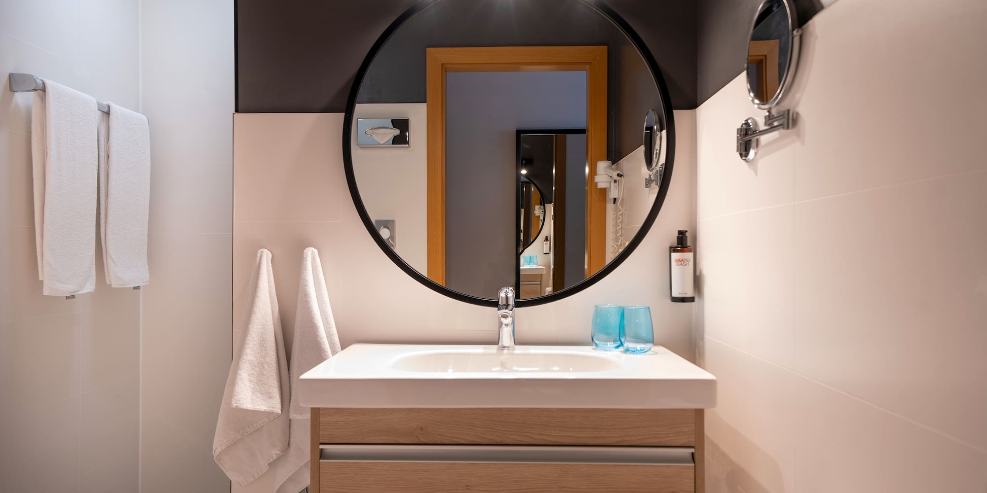 a bathroom with a round mirror