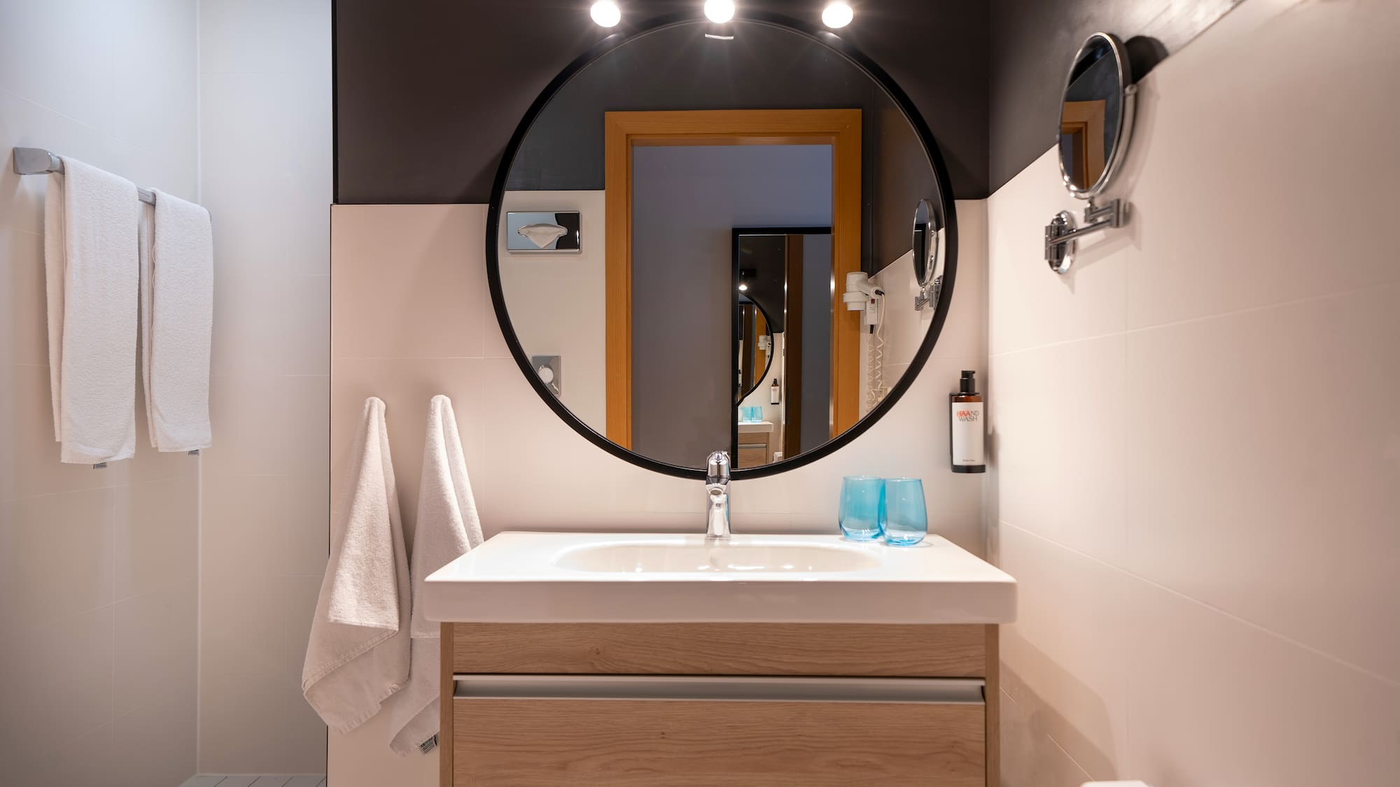 a bathroom with a round mirror