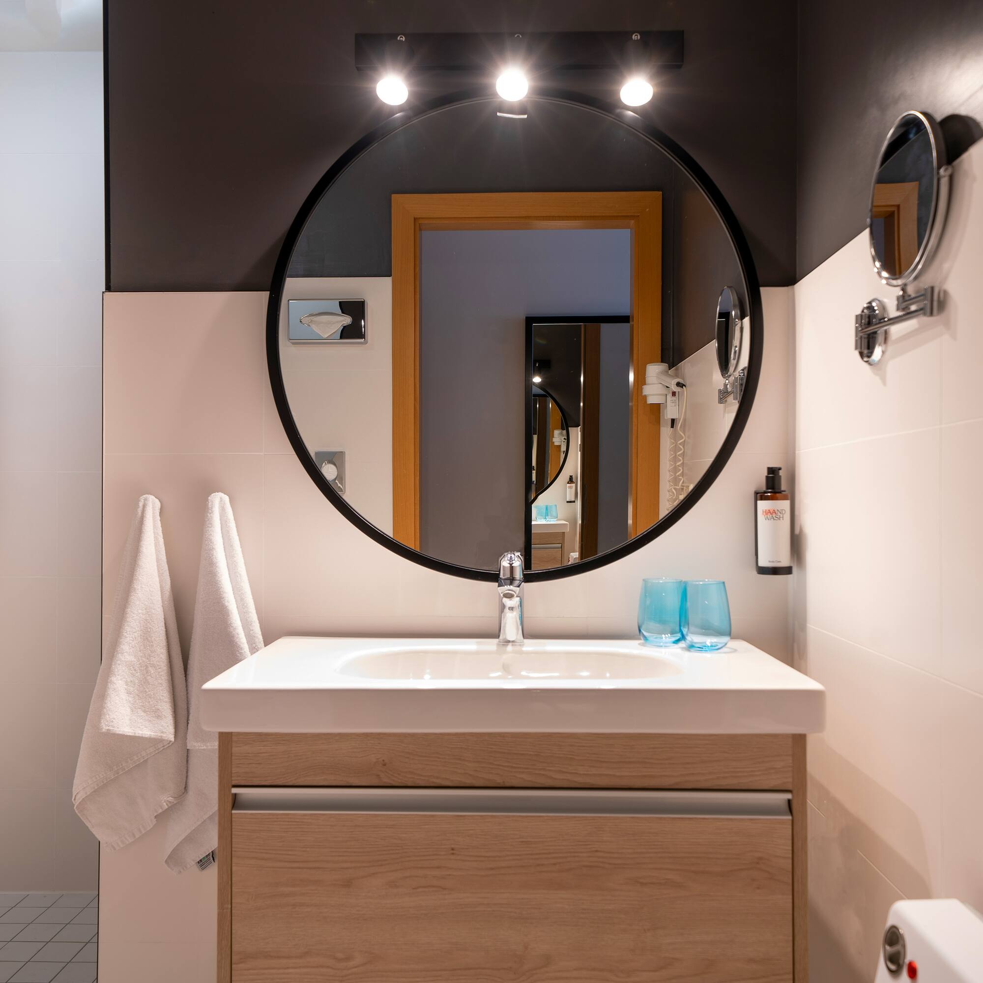 a bathroom with a round mirror