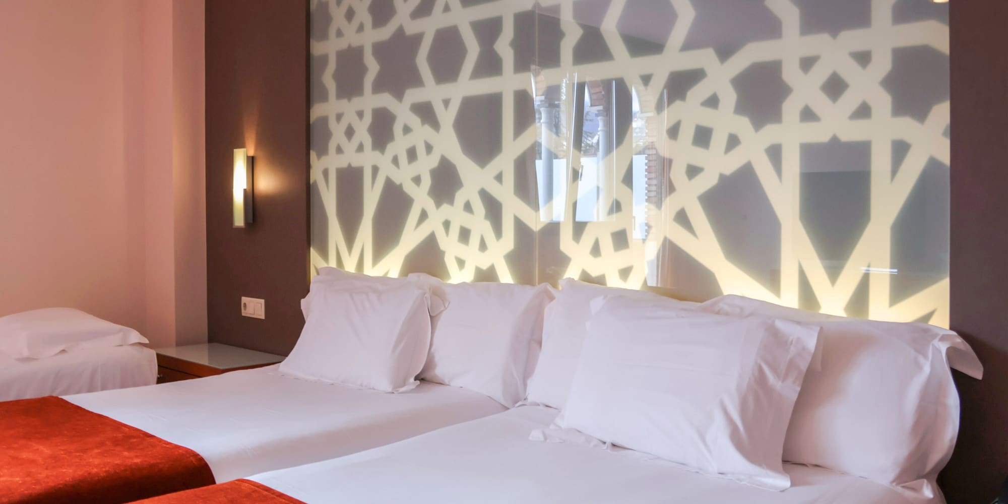 a bed with white pillows and a red blanket