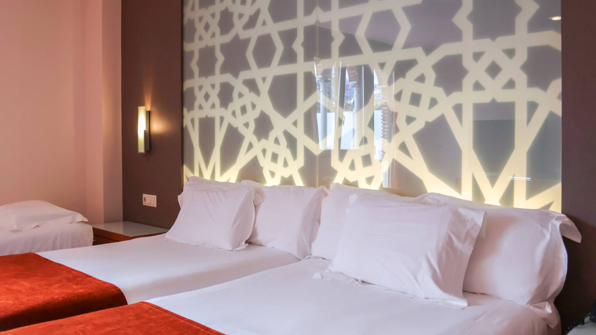 a bed with white pillows and a red blanket