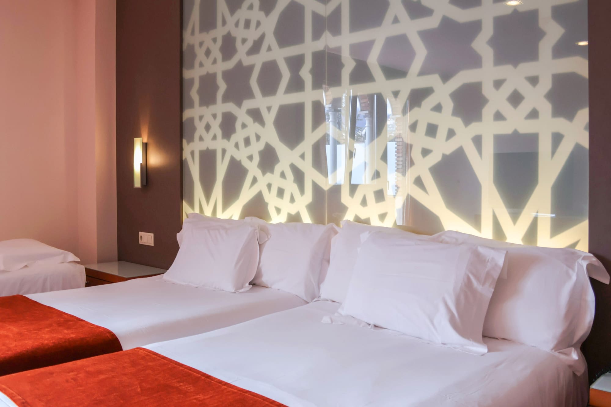 a bed with white pillows and a red blanket