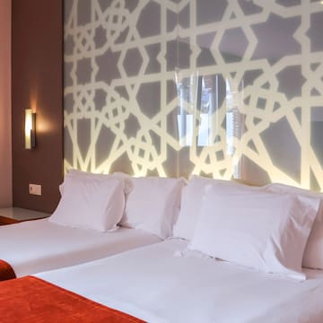 a bed with white pillows and a red blanket