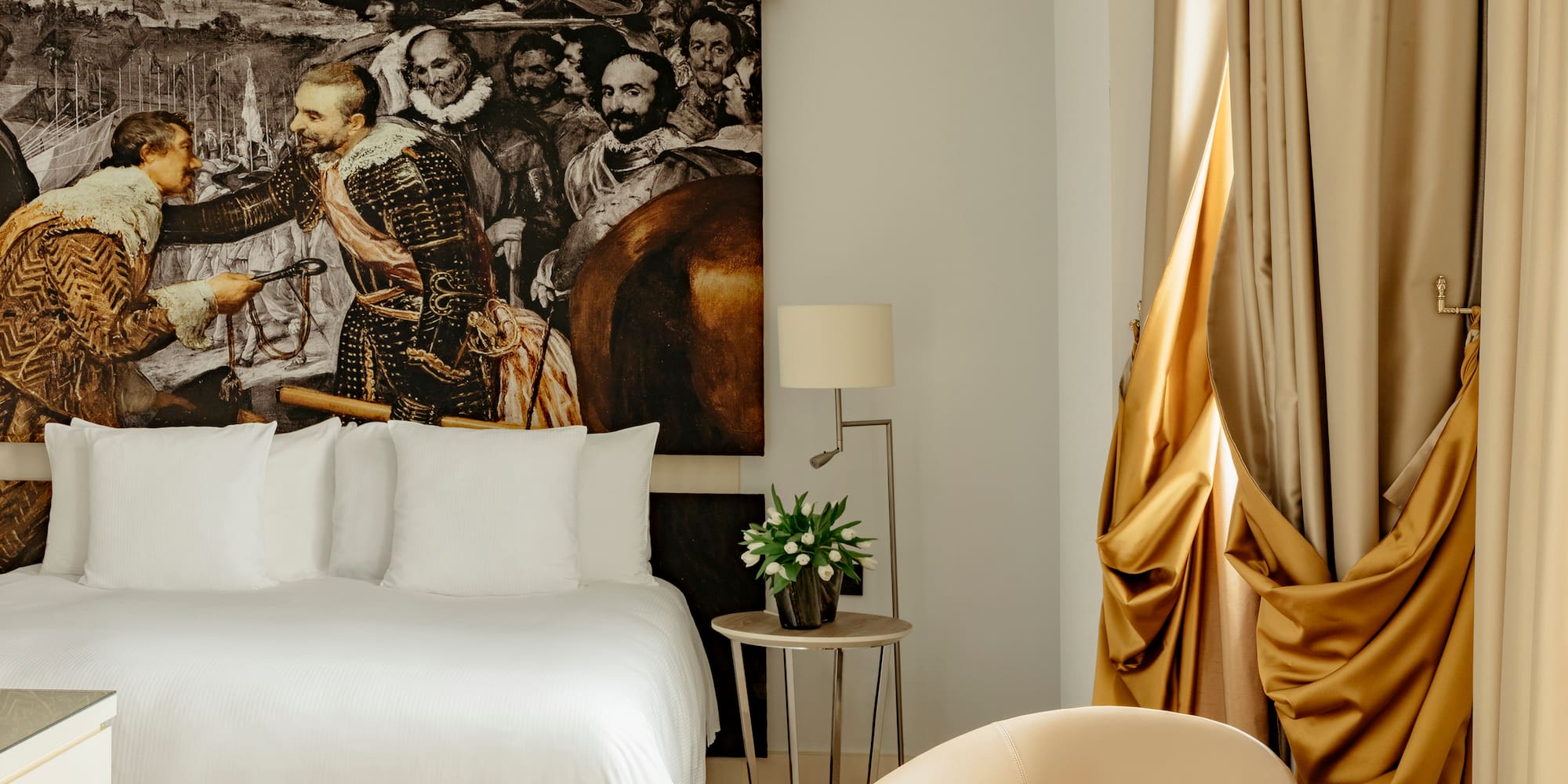 a room with a bed and a painting on the wall