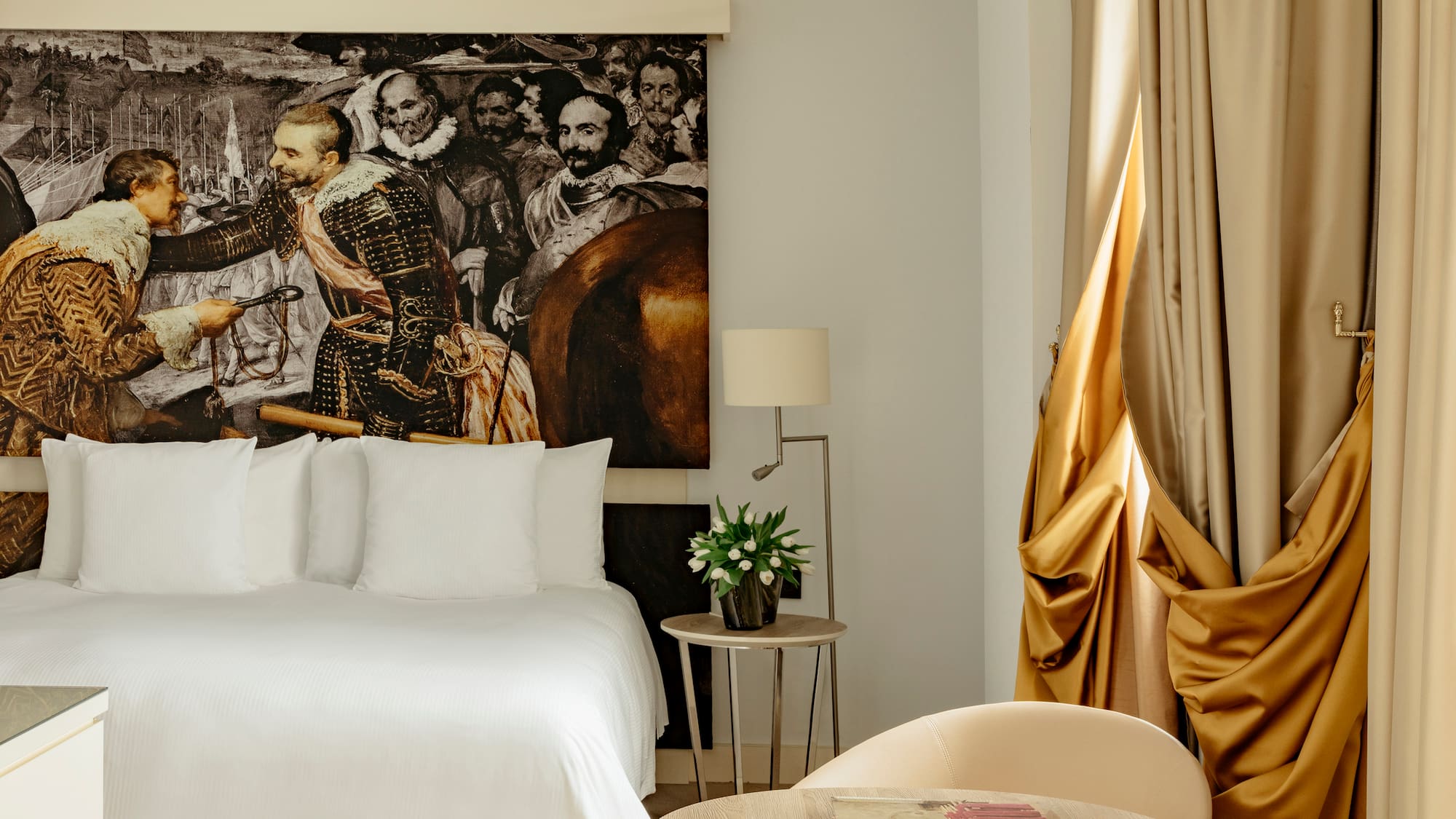 a room with a bed and a painting on the wall