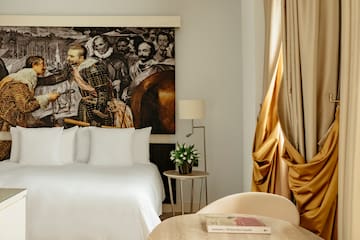 a room with a bed and a painting on the wall