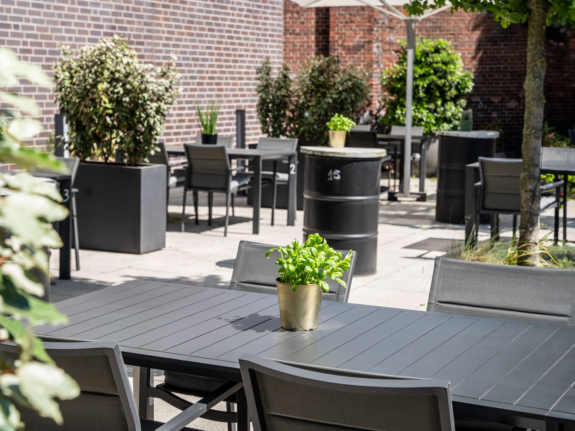 a table and chairs outside with a brick wall 