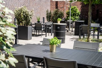 a table and chairs outside with a brick wall 