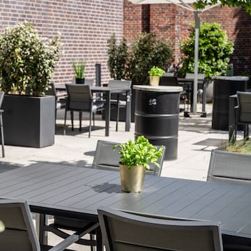 a table and chairs outside with a brick wall and a brick wall