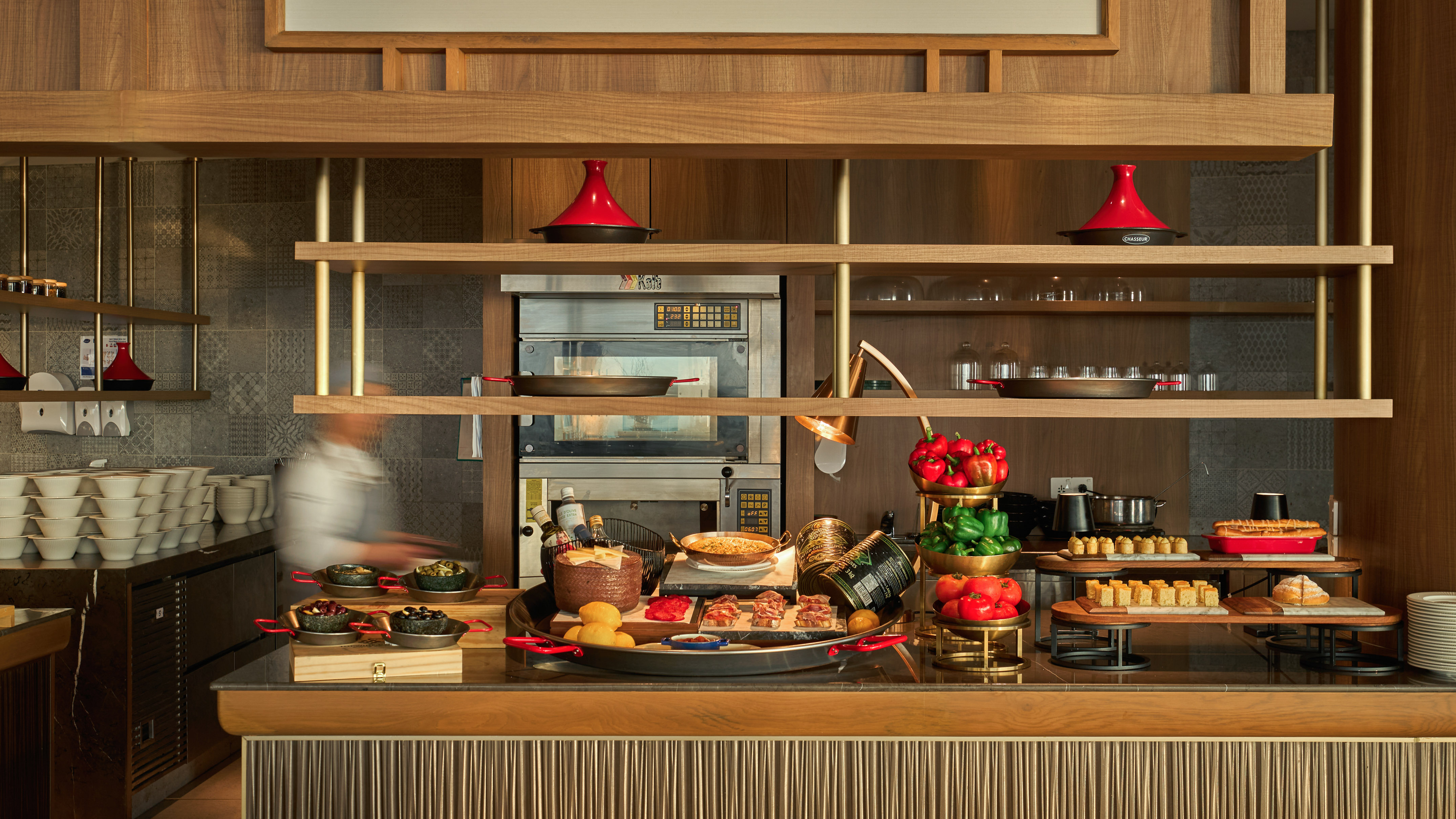 Restaurant buffet with chef, fresh produce, oven station, and diverse dishes.