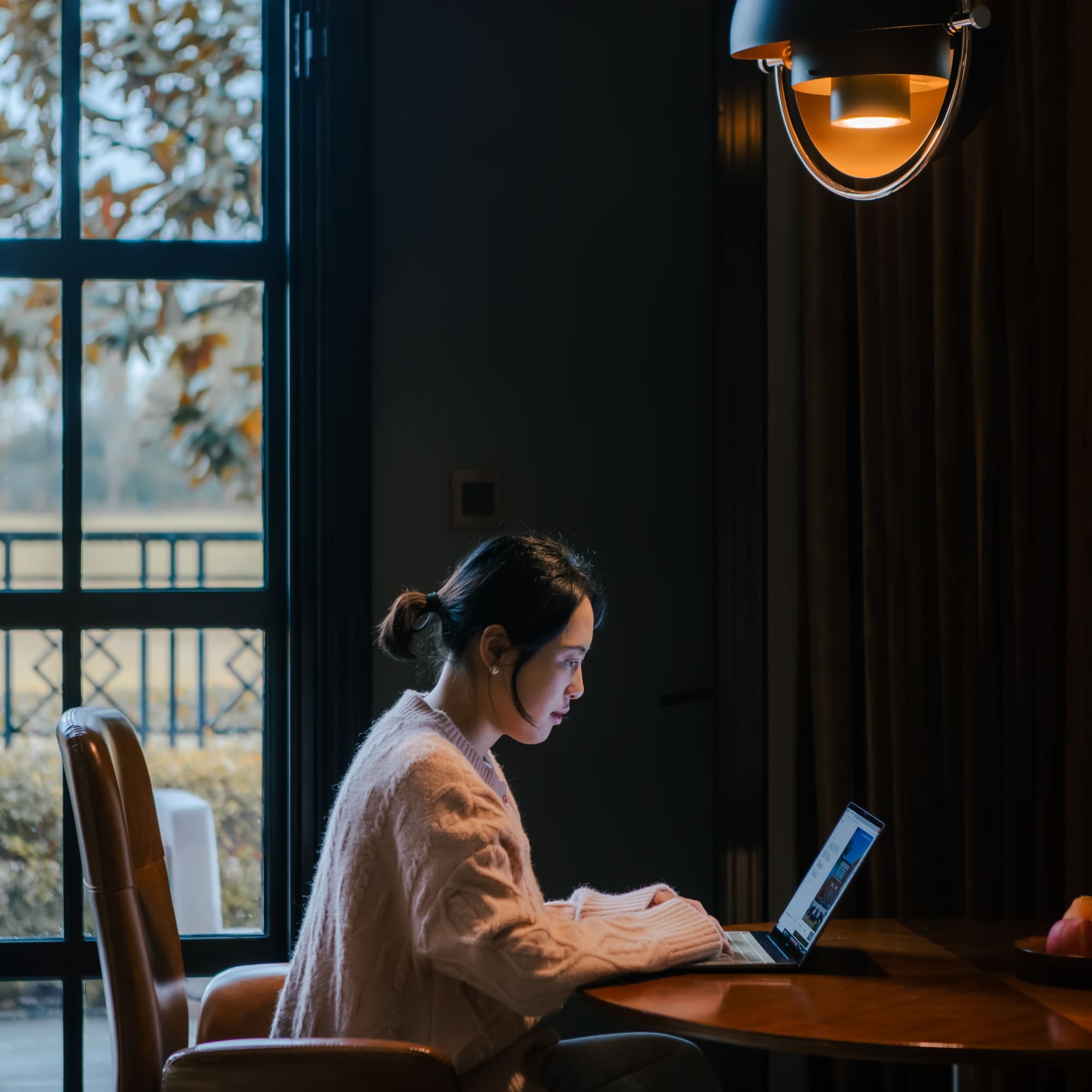 a woman sitting at a table with a laptop