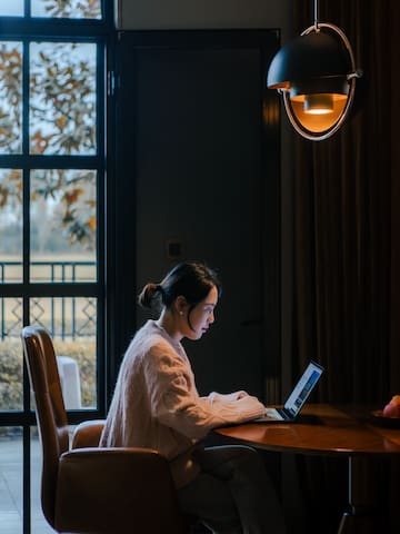 a woman sitting at a table with a laptop