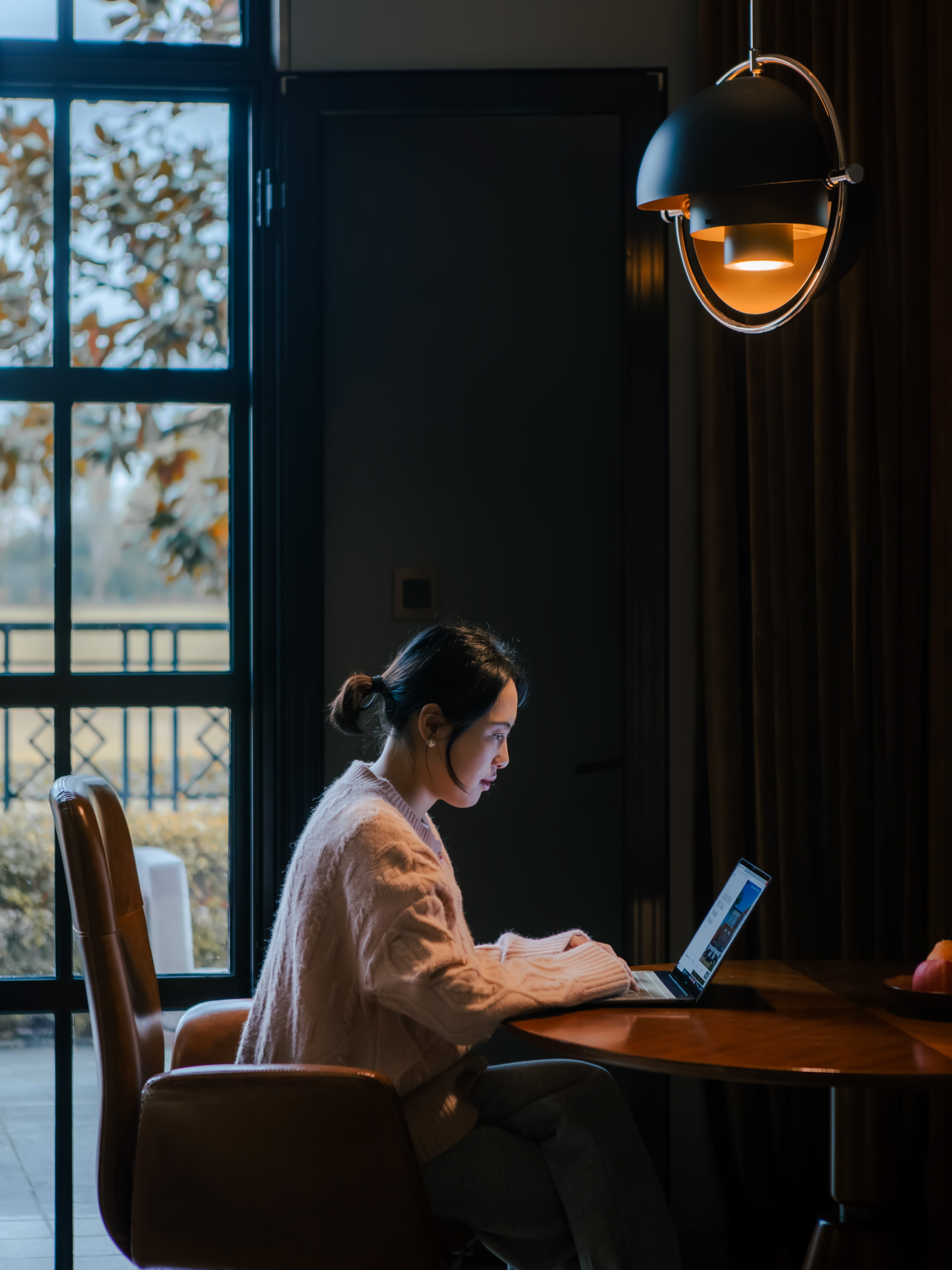 a woman sitting at a table with a laptop