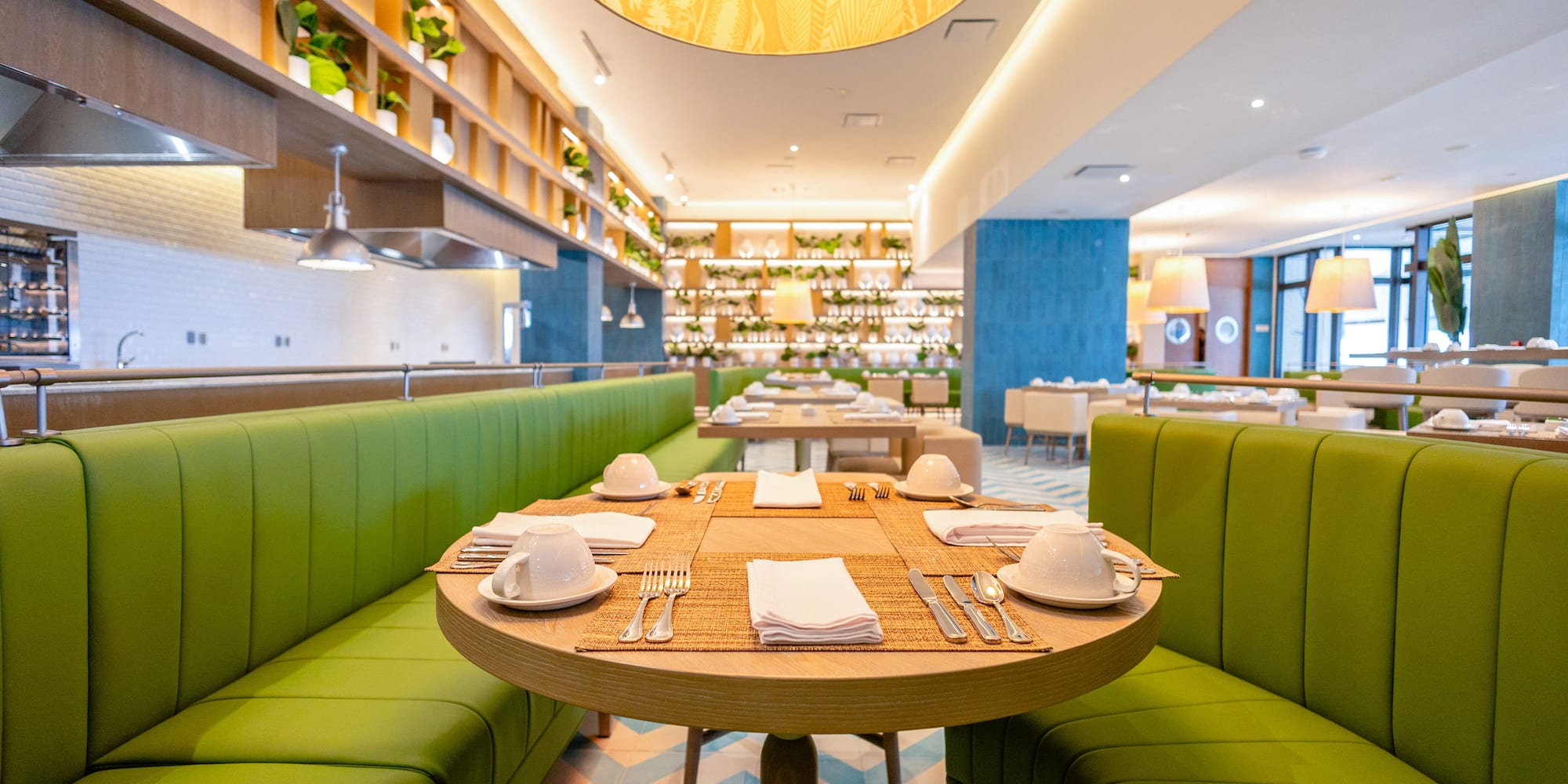 a restaurant with green couches and tables