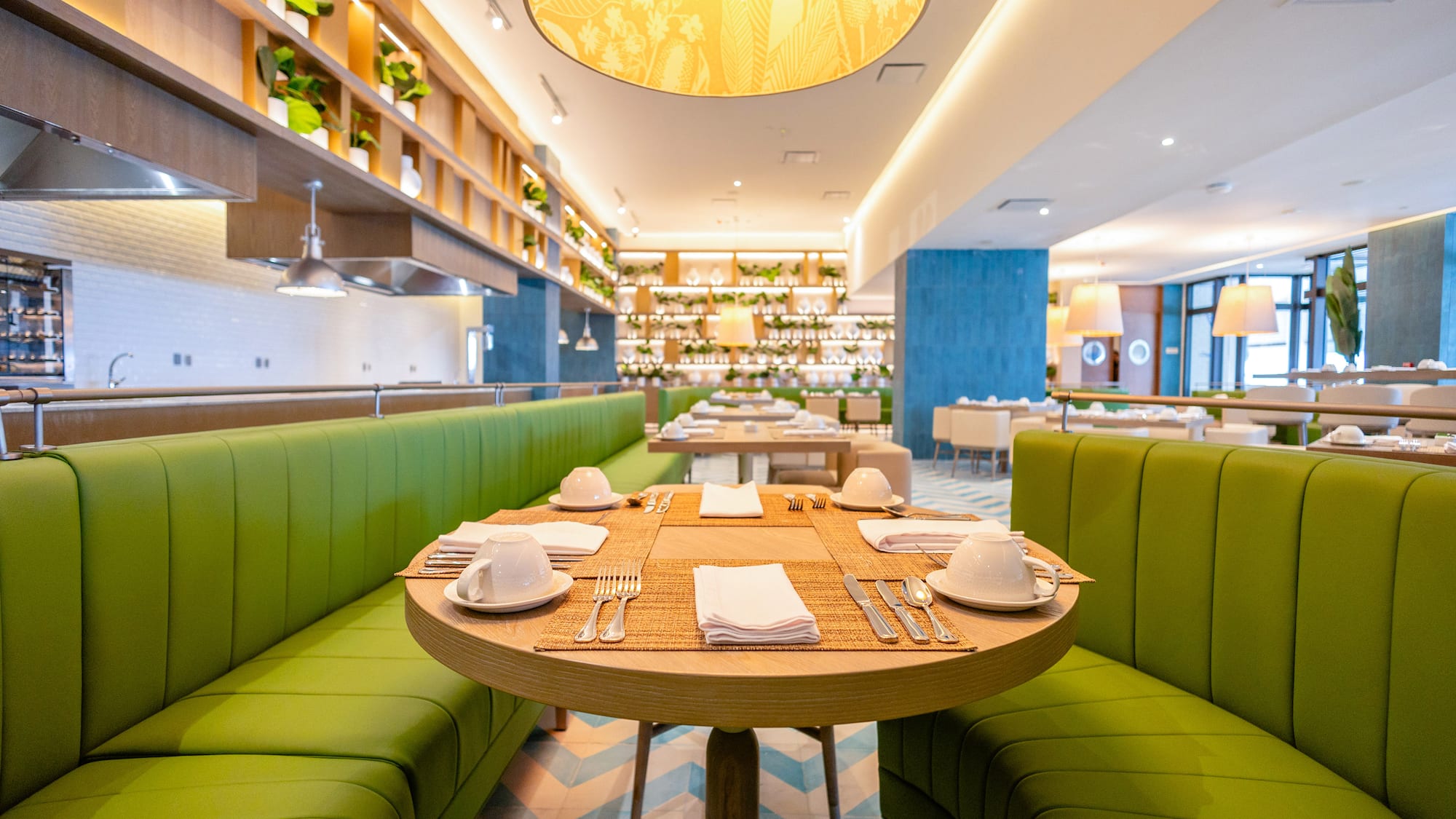 a restaurant with green couches and tables