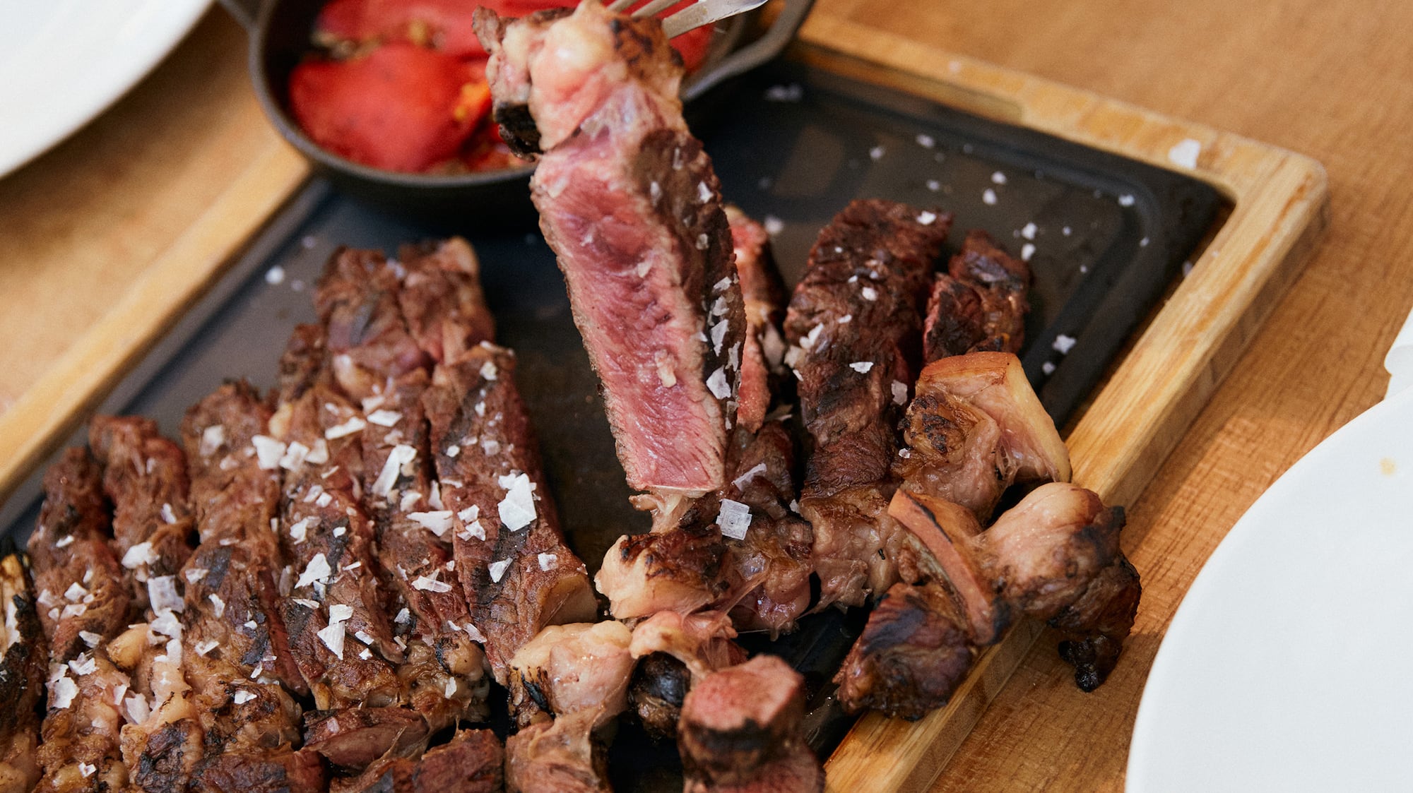 a person holding a fork over a plate of meat