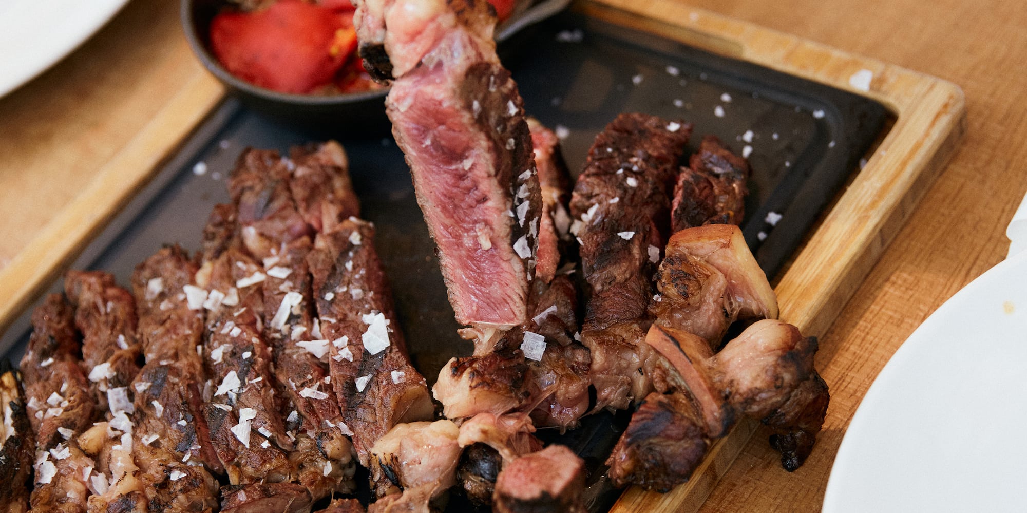 a person holding a fork over a plate of meat