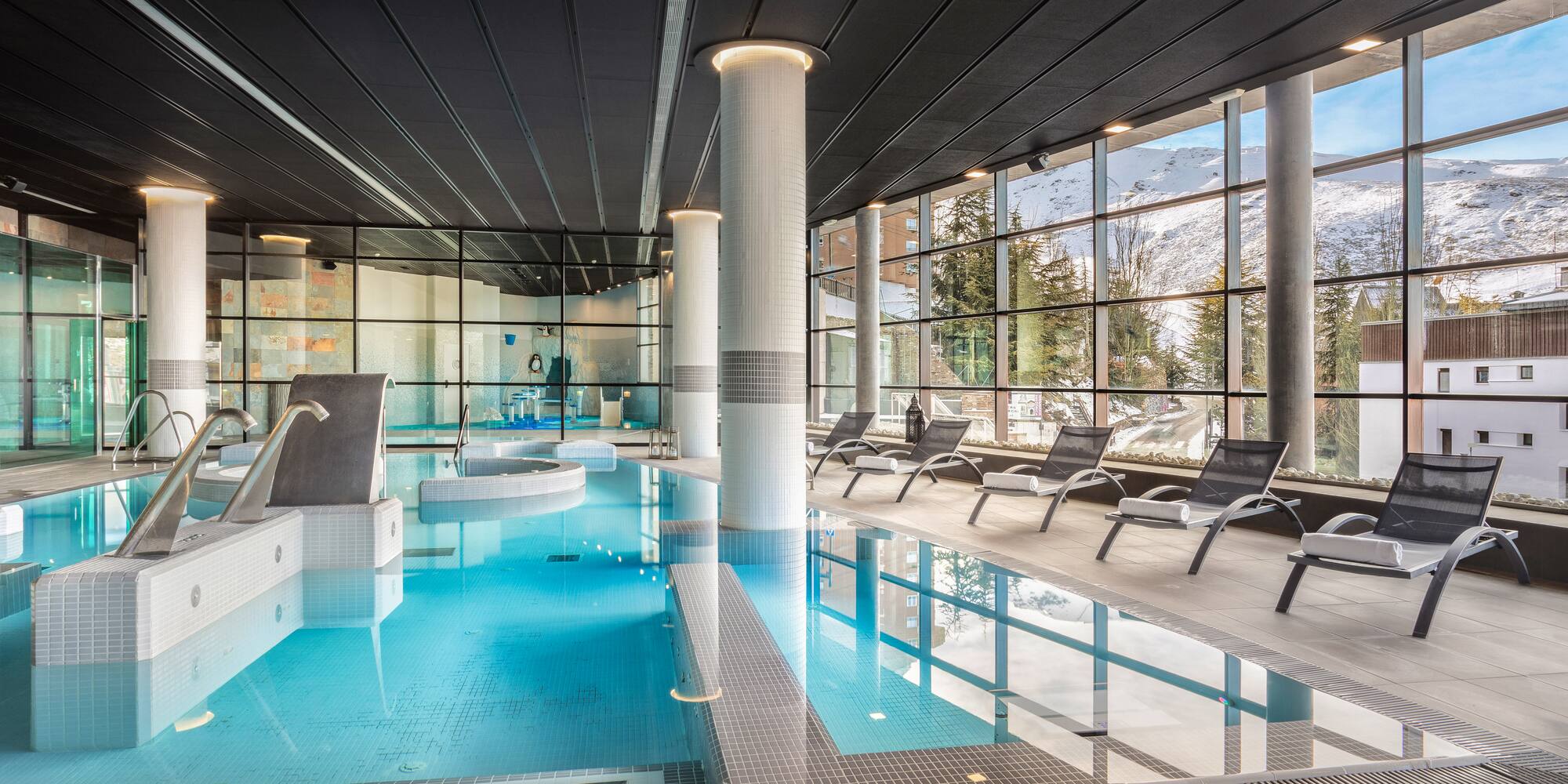 a indoor pool with chairs and a large window