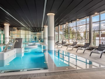 a indoor pool with chairs and a large window