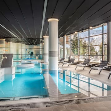 a indoor pool with chairs and a large window