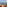 Ocean view balcony with two sun loungers on terracotta tiles overlooking palm trees.