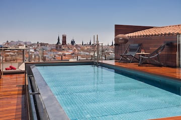 a pool on a roof with a city in the background