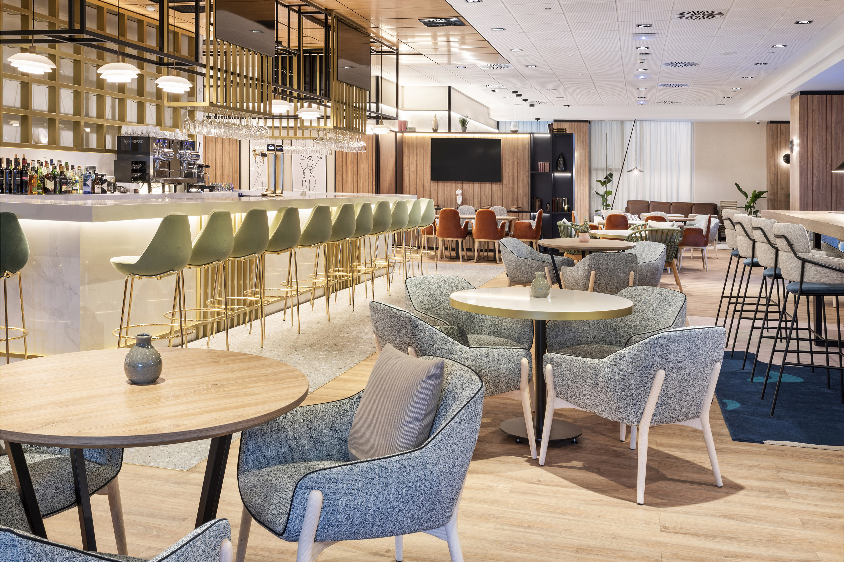 Hotel bar and lounge with modern design, green stools, and diverse seating.