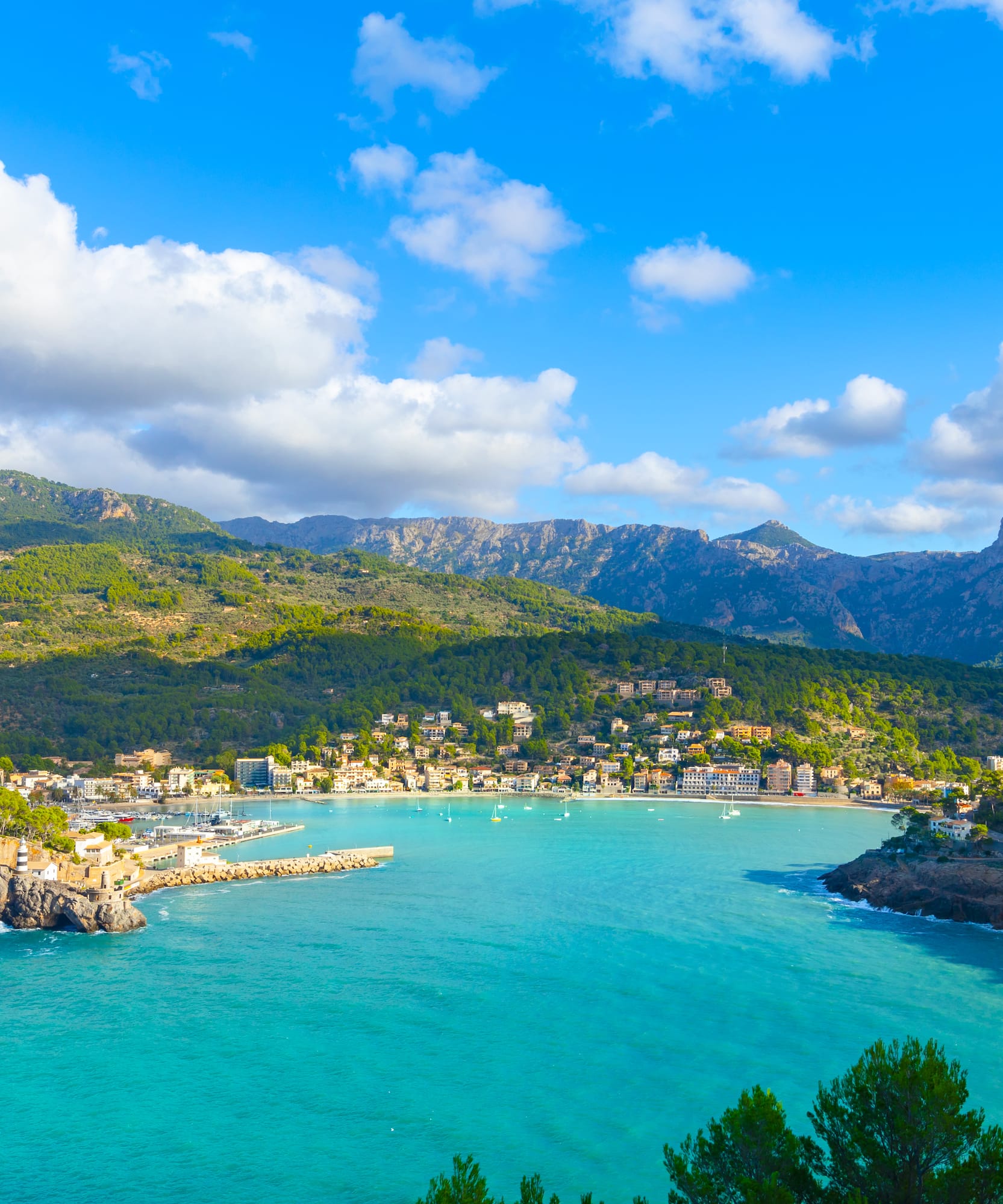 a body of water with a city and mountains in the background