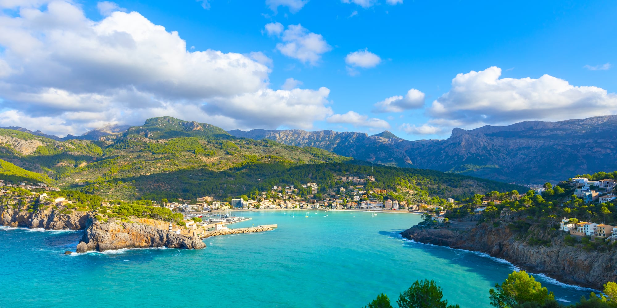 Puerto de Sóller, Mallorca: bahía turquesa, pueblo costero y montañas verdes.