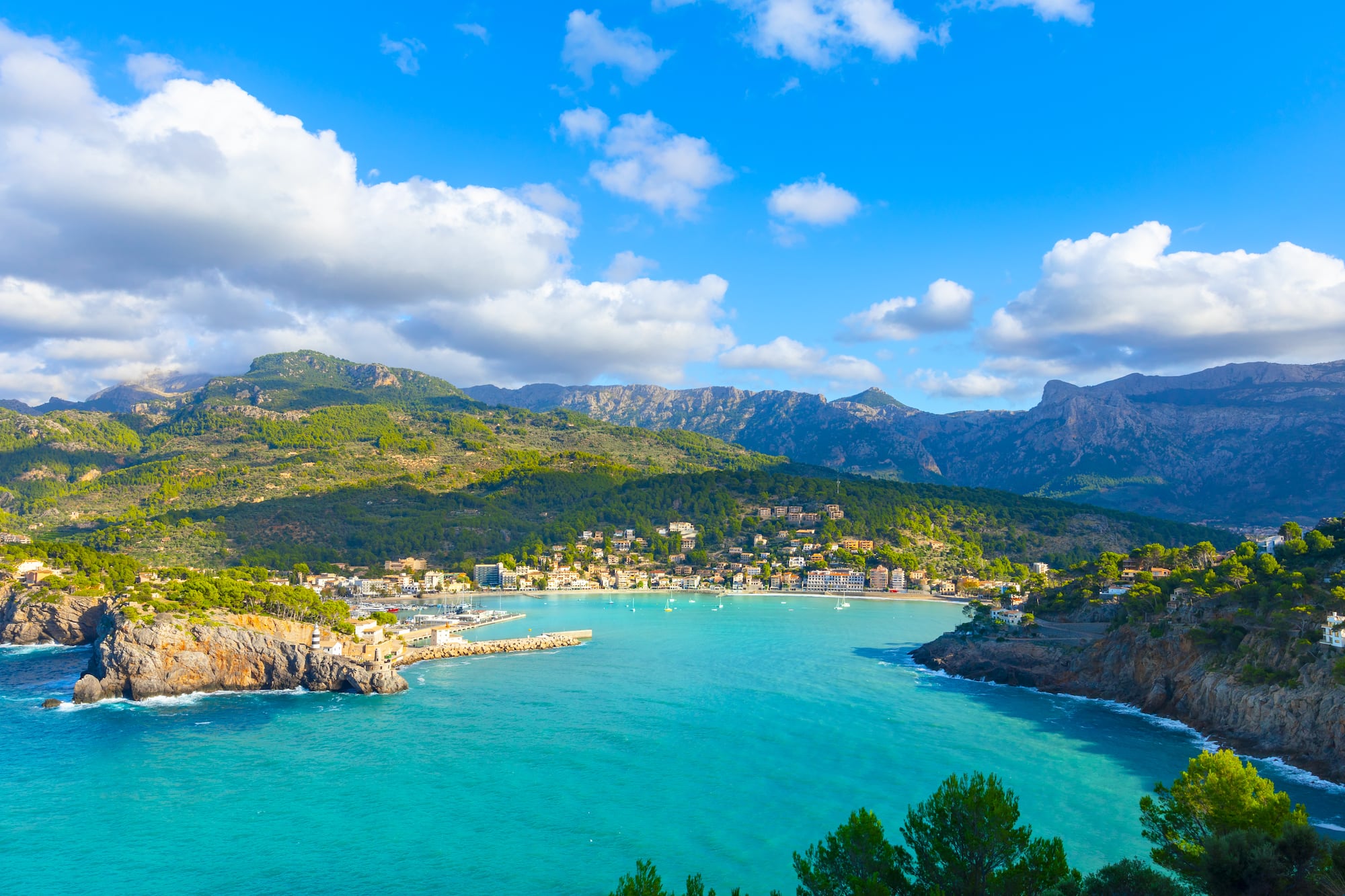 a body of water with a city and mountains in the background