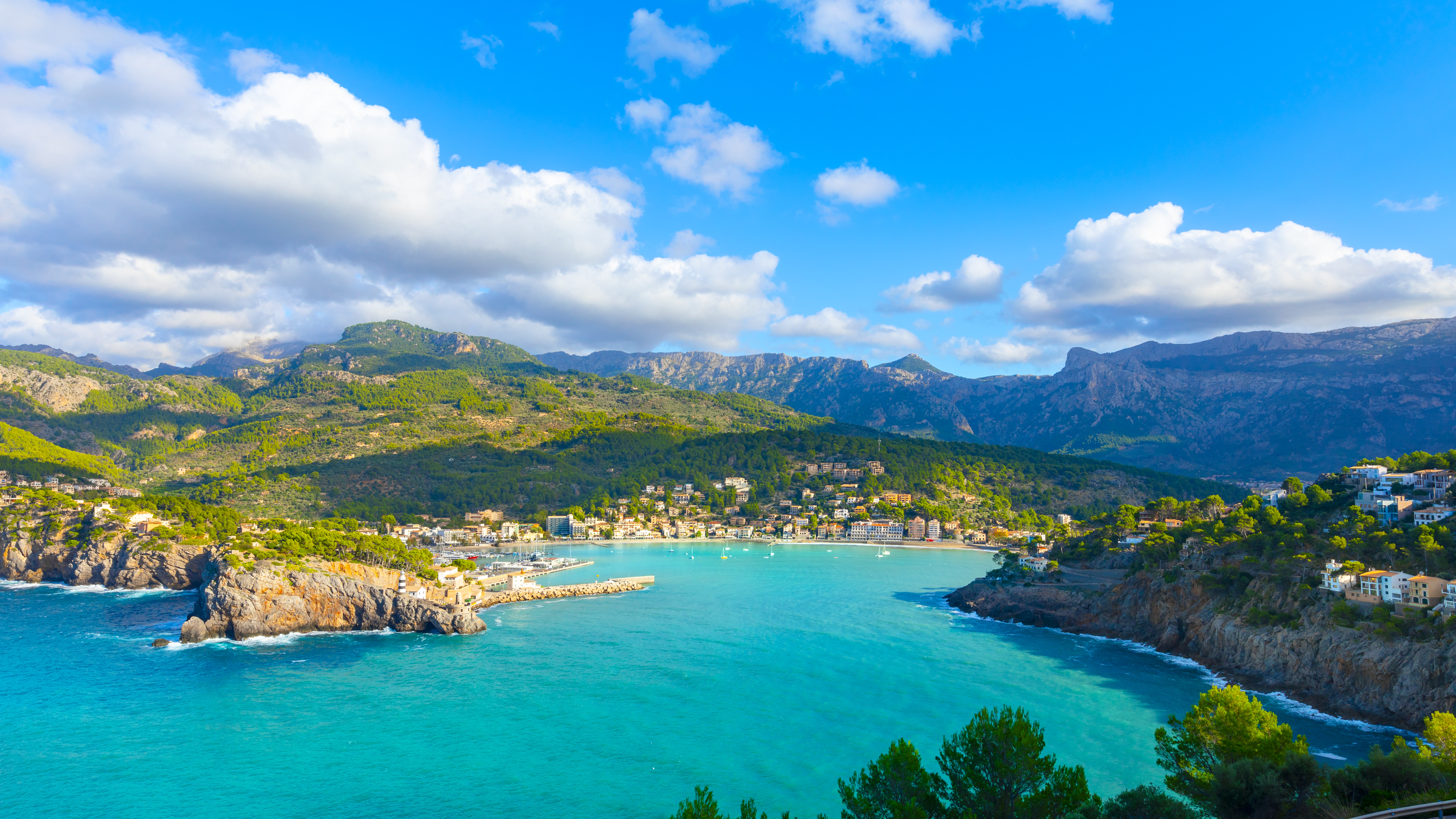 Puerto de Sóller, Mallorca: bahía turquesa, pueblo costero y montañas verdes.