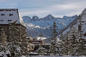 a snowy mountain range with buildings and trees